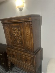 This is an antique Jacobean or Jacobean Revival style oak china cabinet.