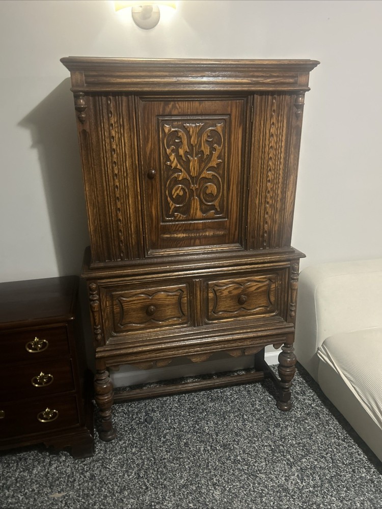 This is an antique Jacobean or Jacobean Revival style oak china cabinet.