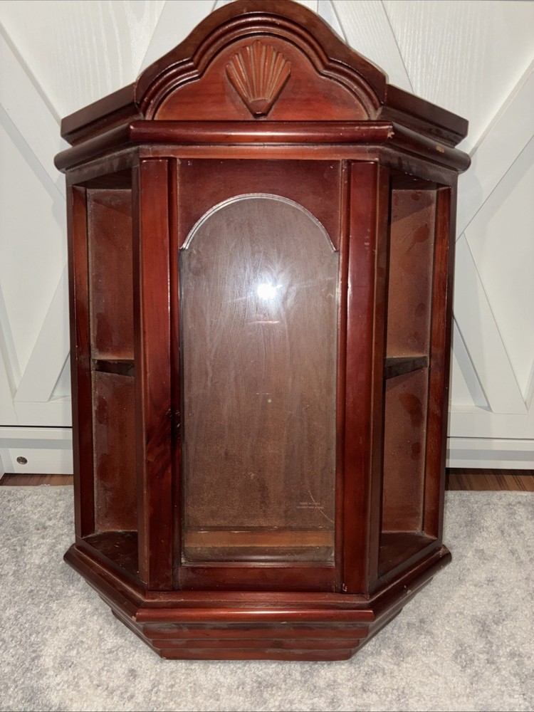 Vintage wall mounted dark wooden curio cabinet with shell shaped pediment
