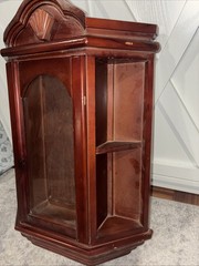 Vintage wall mounted dark wooden curio cabinet with shell shaped pediment